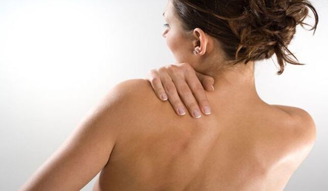 La femme s'inquiète de la douleur sous l'omoplate gauche dans le dos du dos